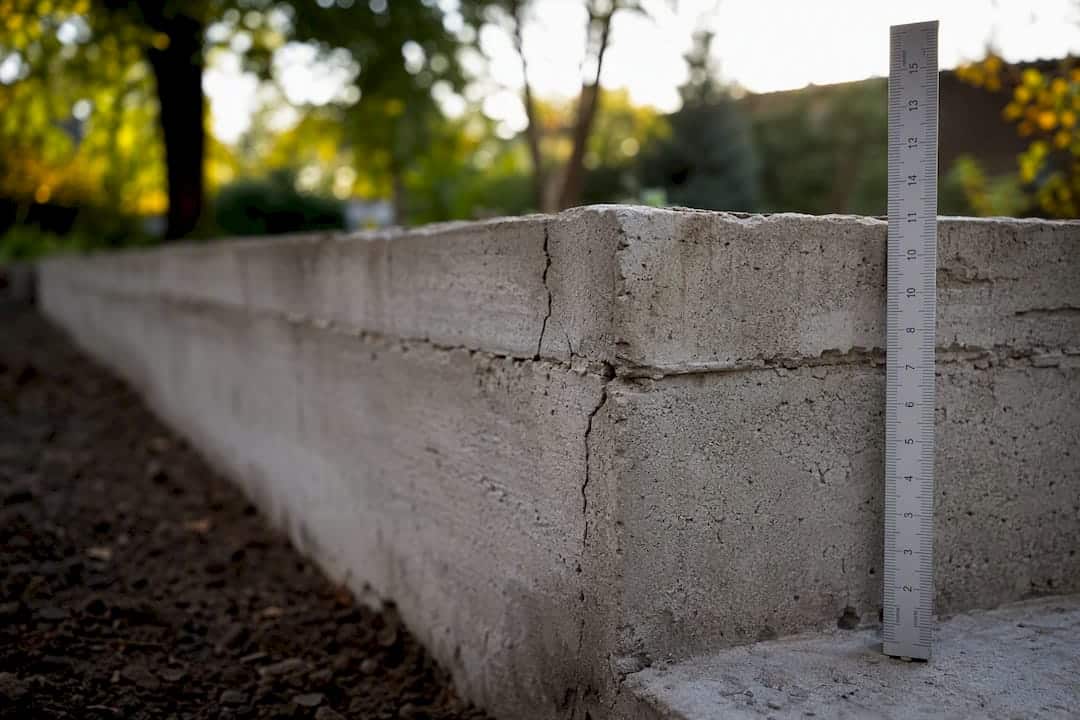 Close-up van een scheur in de fundering met meetlint